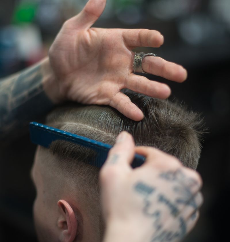 Barber giving a client a fade haircut with clippers